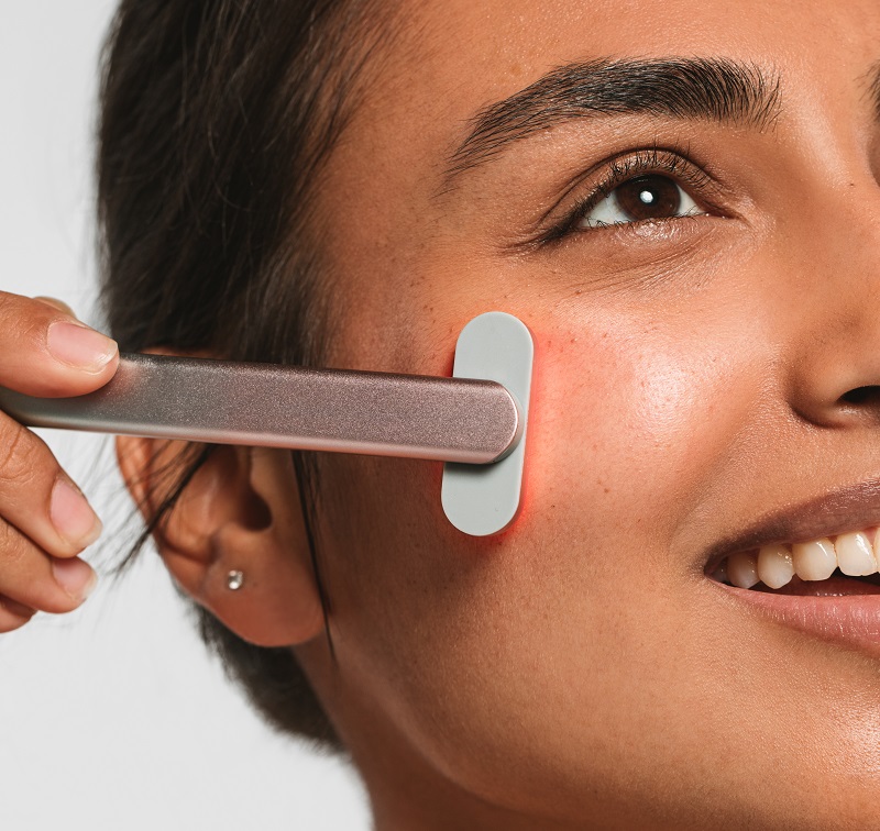 Woman using red light therapy product