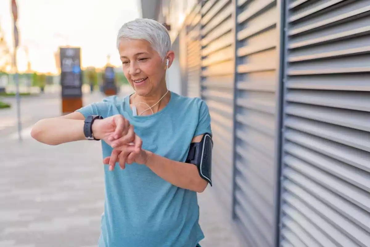 Smiling older woman looking at her fitness wearable
