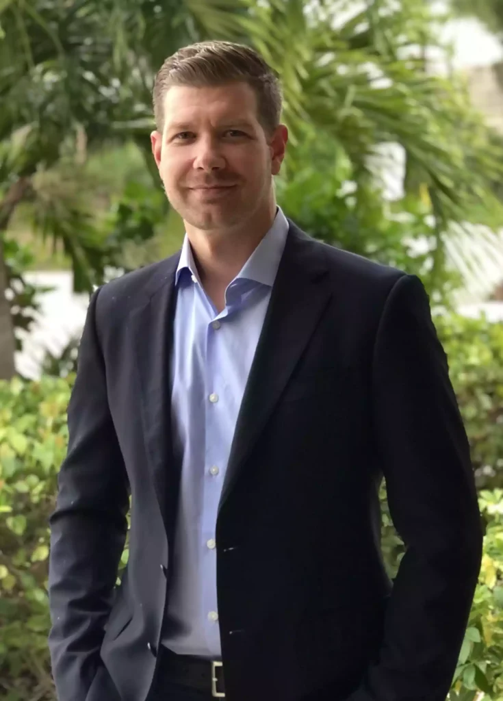 Jay Diederich standing in suit with hands in pockets