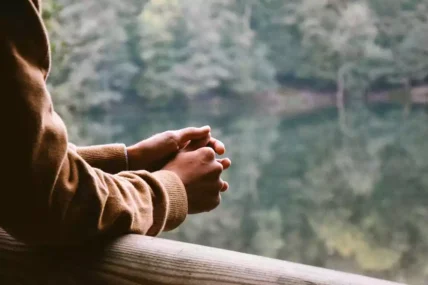 Man standing on a balcony overlooking nature