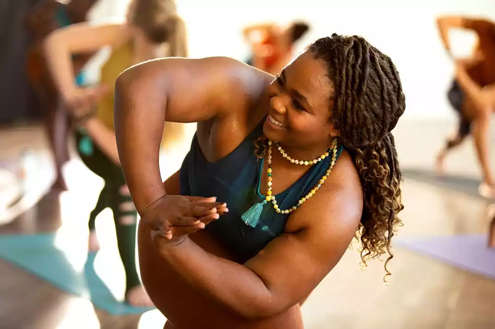 A black woman doing yoga at a CorePower Yoga session