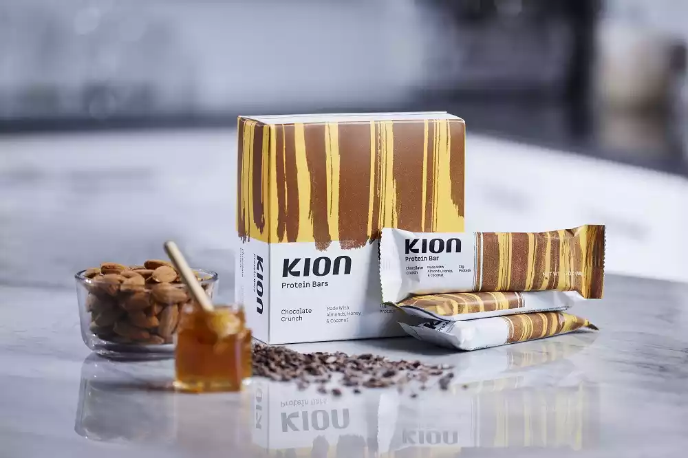 The Kion Chocolate Crunch Protein Bar and its ingredients on a surface