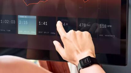 A hand wearing Apple Watch operating Ergatta rower software