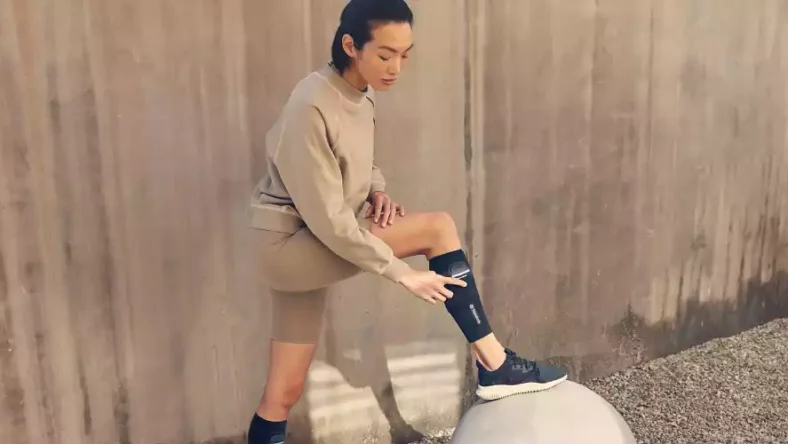 Man wearing Therabody RecoveryPulse compression wearable with vibration