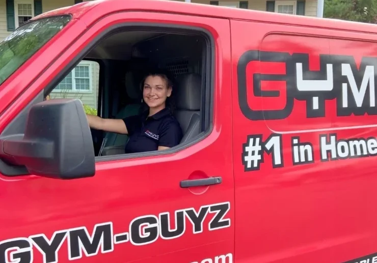 A personal trainer in a red mobile van from GymGuyz