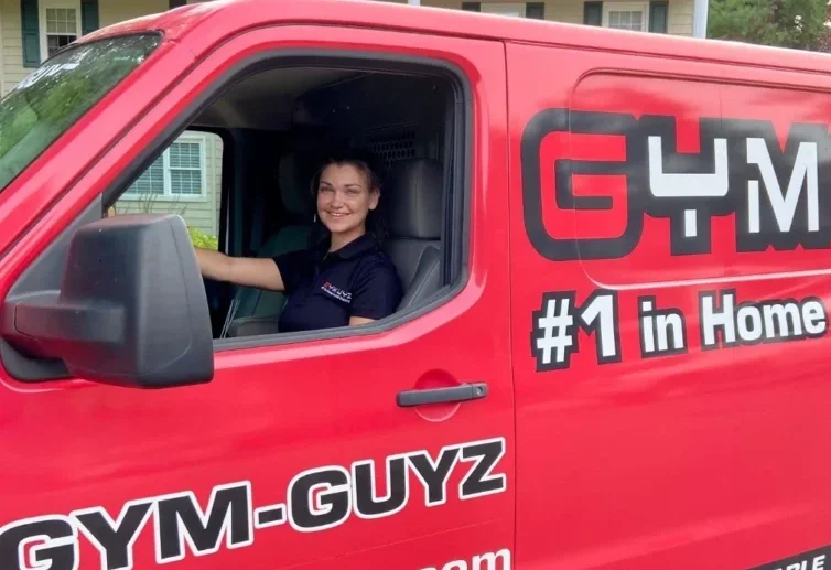 A personal trainer in a red mobile van from GymGuyz