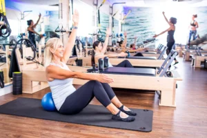 woman works out on a Pilates reformer