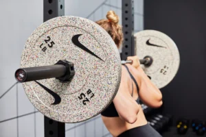 woman works out with Nike barbell and bumper plates