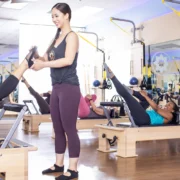 an image of a Club Pilates studio and members working out on reformers