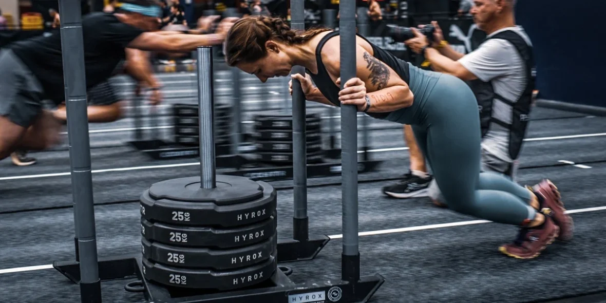 Woman pushing sled of weights