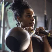 Young Black woman doing a double kettlebell hold