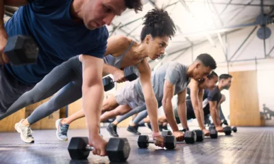 people perform renegade rows inside a gym