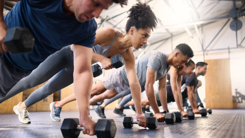 people perform renegade rows inside a gym