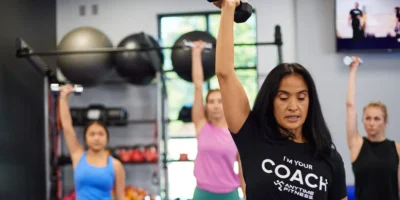 An Anytime Fitness coach leading a small group strength class.