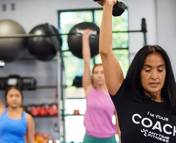 An Anytime Fitness coach leading a small group strength class.