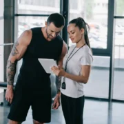 Man and woman at gym looking at smart tablet
