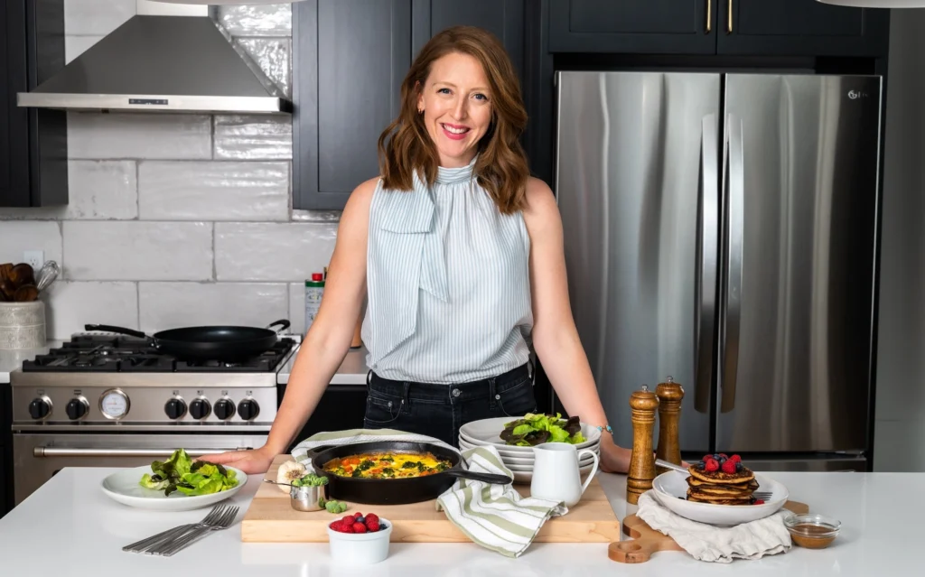 a smiling image of Dr. Casey Means in a kitchen