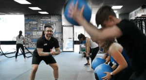 Personal trainer teaching a class with medicine balls