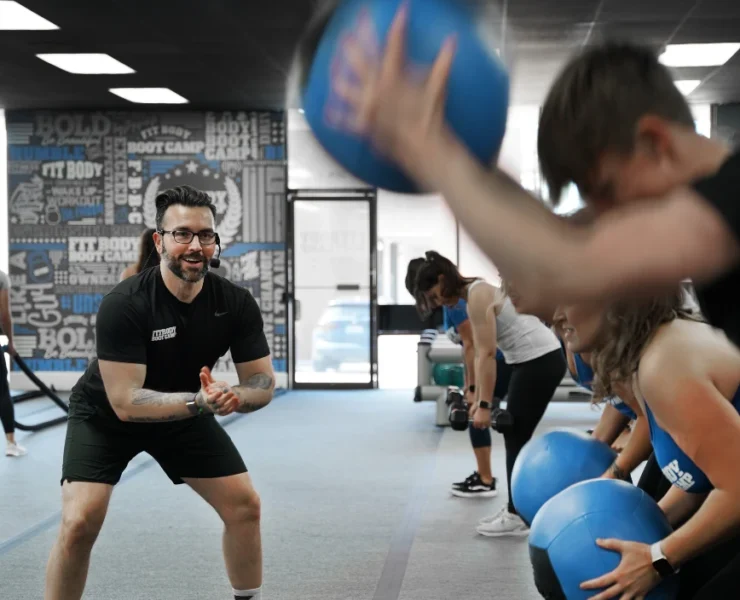 Personal trainer teaching a class with medicine balls