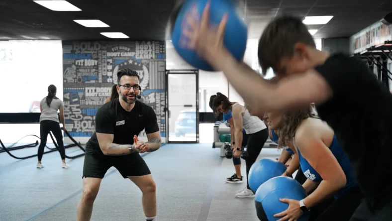 Personal trainer teaching a class with medicine balls
