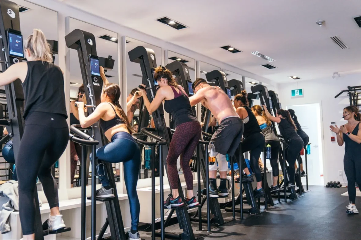 people on VersaClimber machines inside a fitness studio