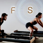 Man and woman on Pilates reformers