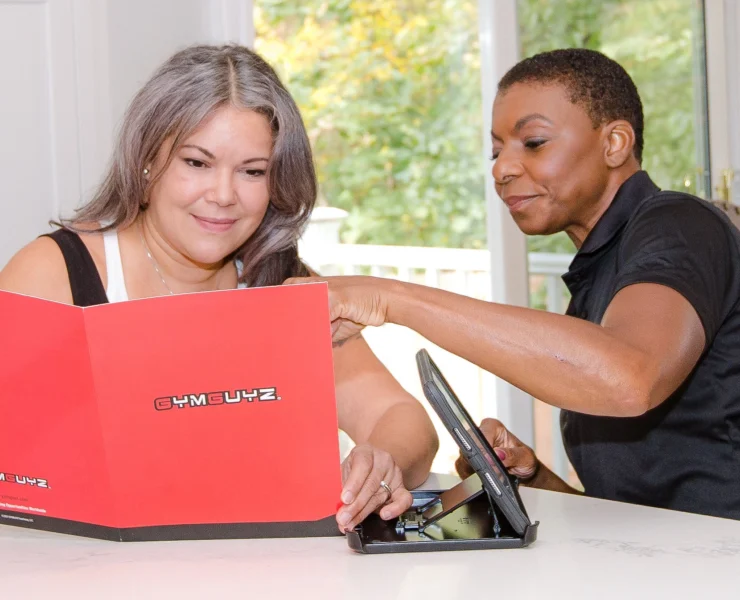 personal trainer talking to client at kitchen table