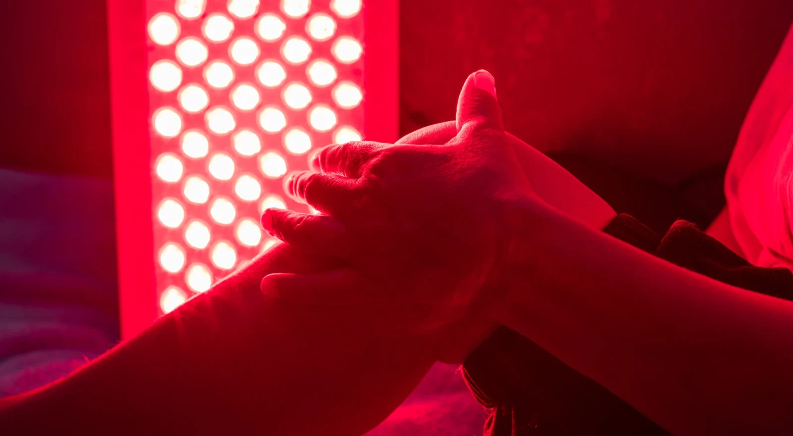 Person grabbing knee, red light therapy