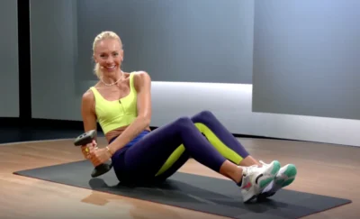 Peloton instructor works out with a dumbbell