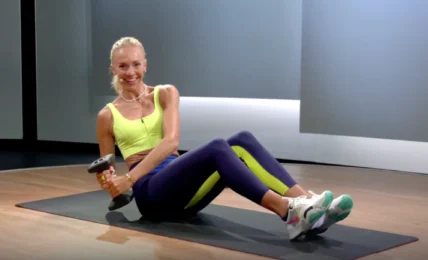 Peloton instructor works out with a dumbbell