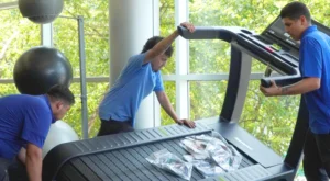 young men installing treadmill