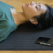 Woman lying on yoga mat eyes closed