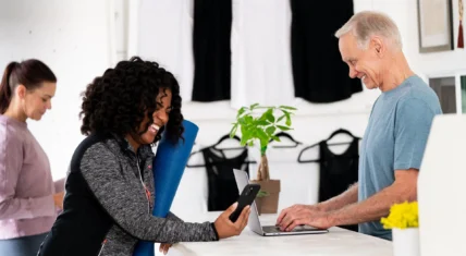 Black lady at desk talking to white man