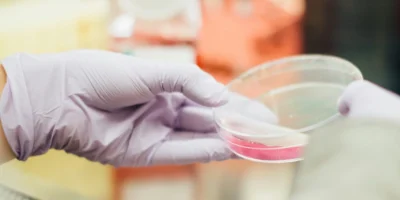 person in lab with plastic container