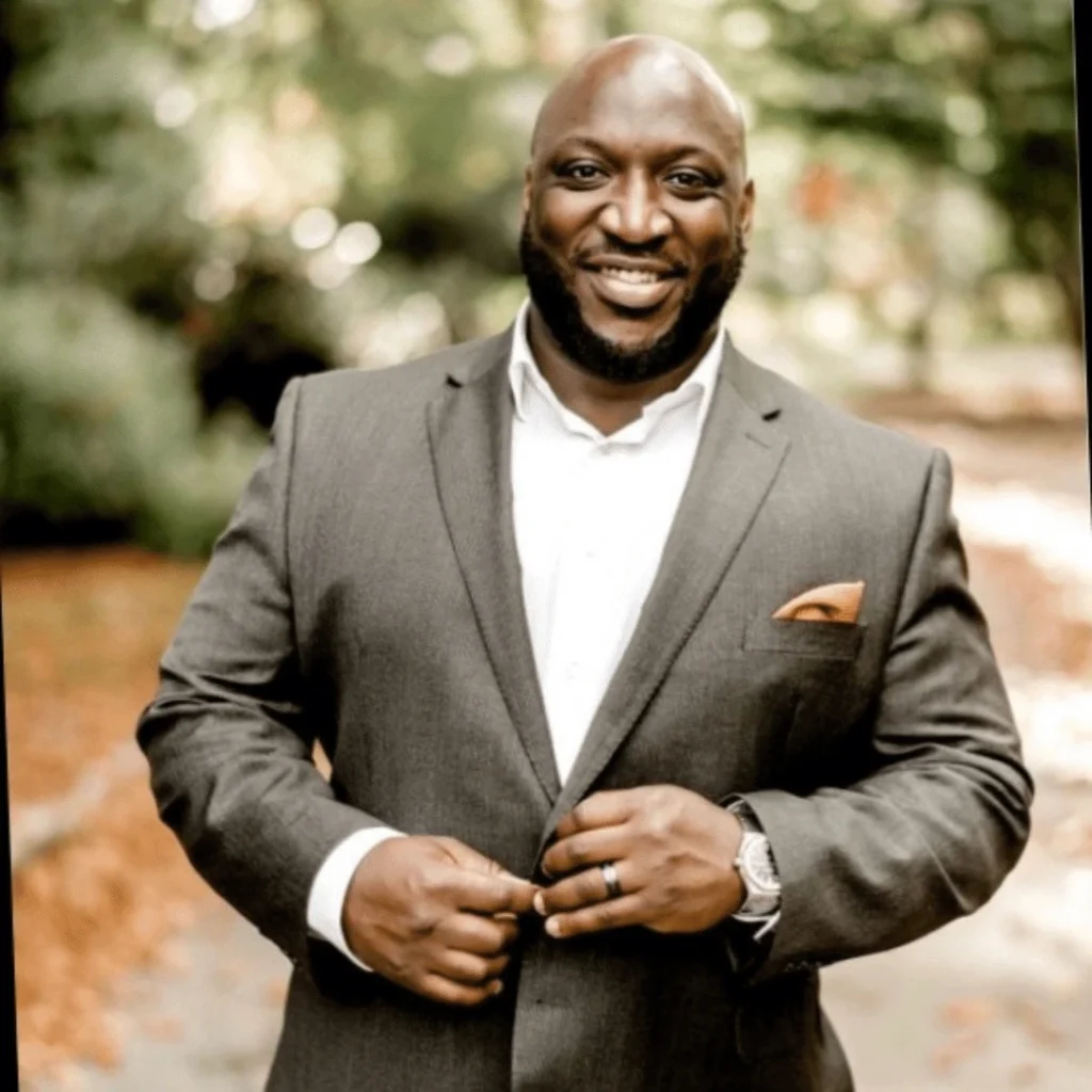 man smiling in suit and glasses