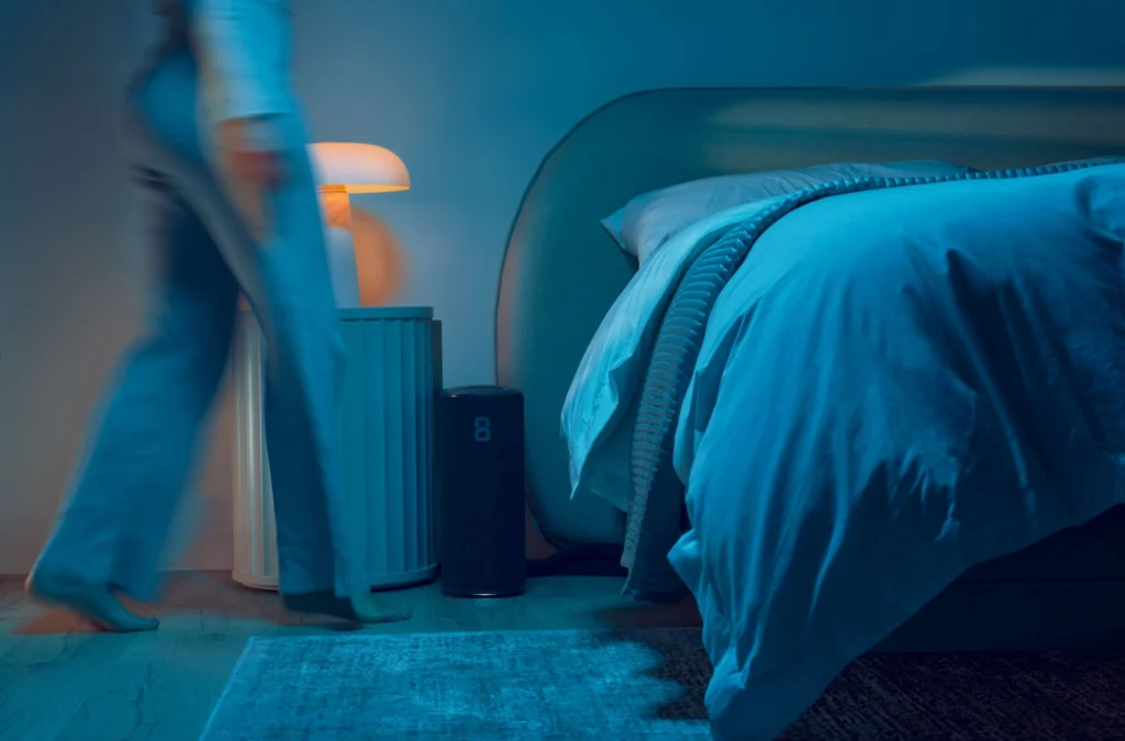 woman stands next to bed with an Eight Sleep cover