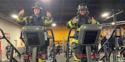 two firefighters on stairclimbers