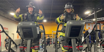 two firefighters on stairclimbers