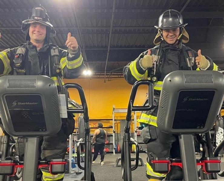 two firefighters on stairclimbers