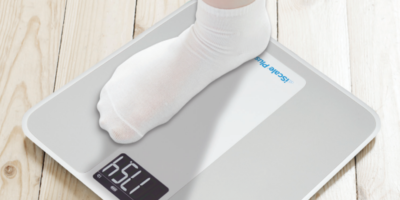 An image of a socked foot stepping on a Smart Meter iScale.