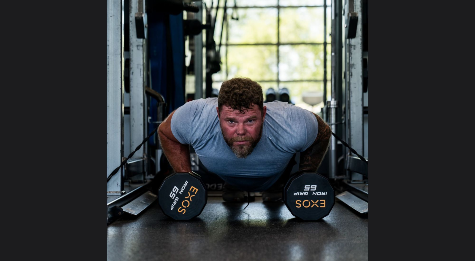 man doing pushups with weights