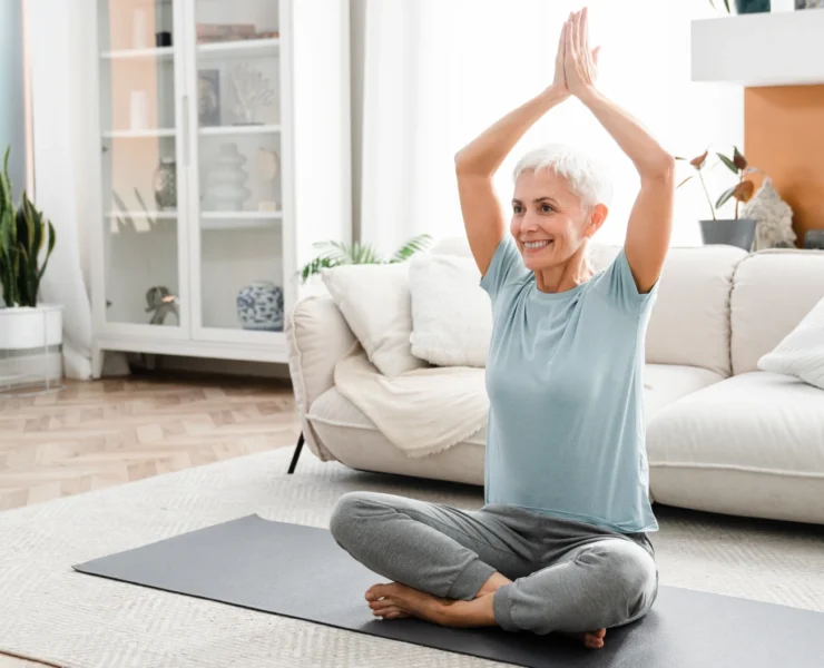 older woman doing yoga at home