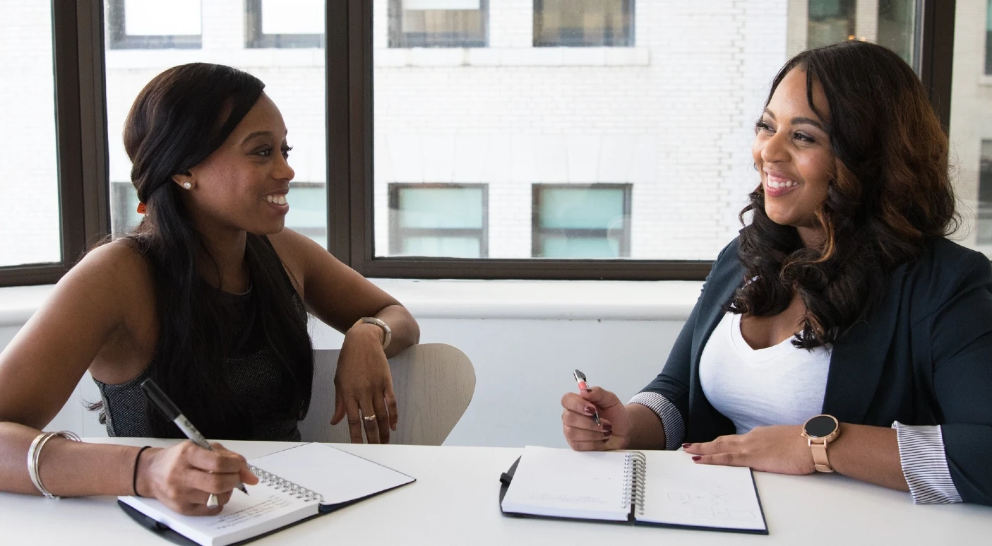 Two professional black women sitting at a table