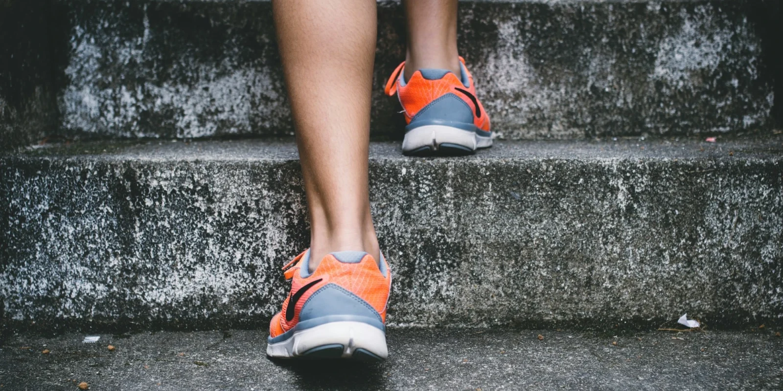 person in sneakers walking up steps