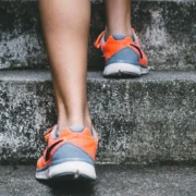 person in sneakers walking up steps