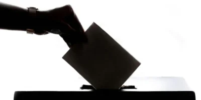 voter placing ballot in box