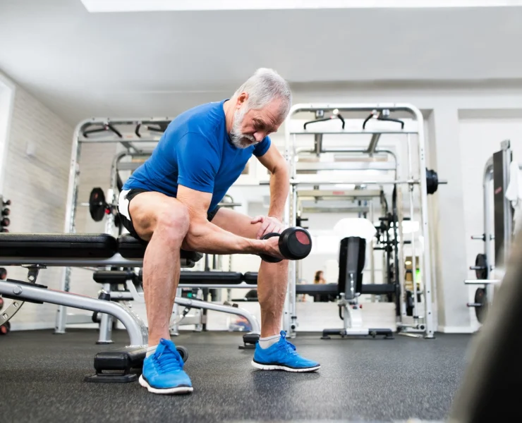 older man works out inside a gym