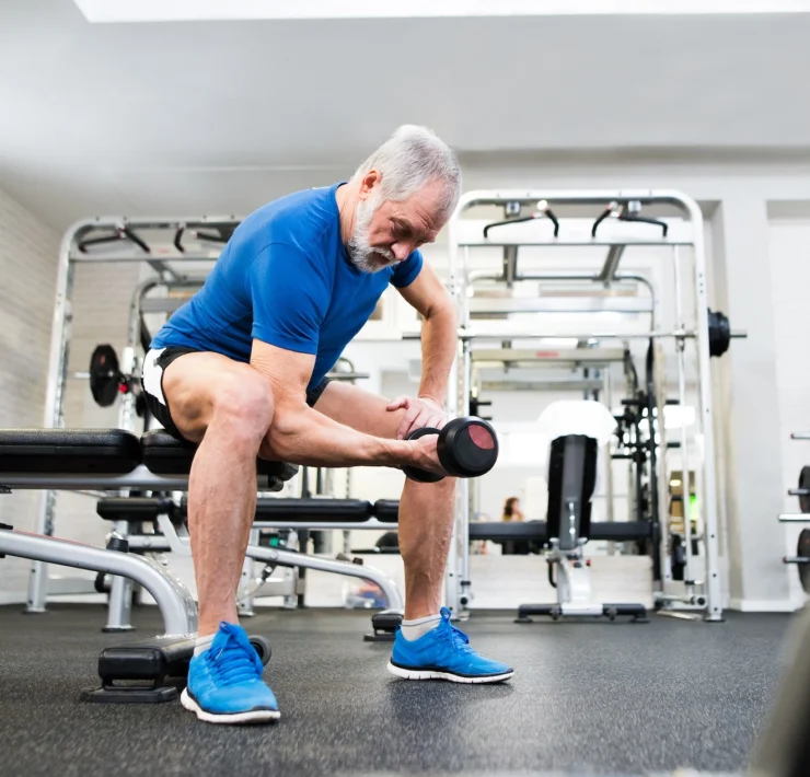 older man works out inside a gym