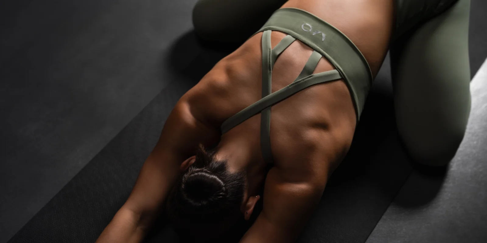 an image of a woman wearing a ASRV women's activewear and stretching on a yoga mat