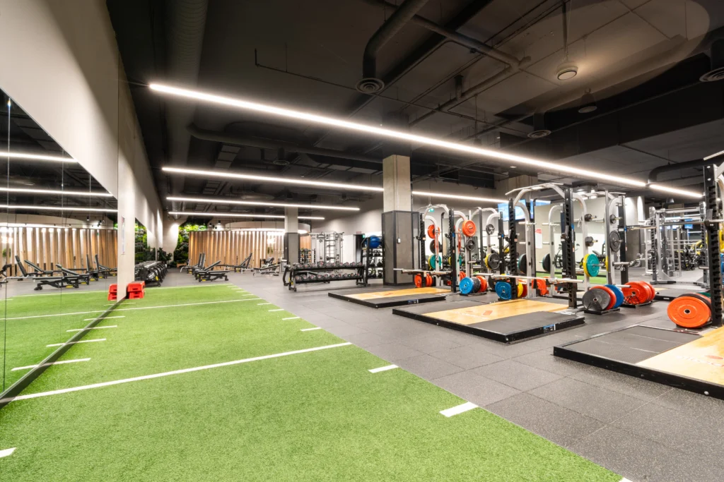 weight lifting platforms and a turf field inside a gym